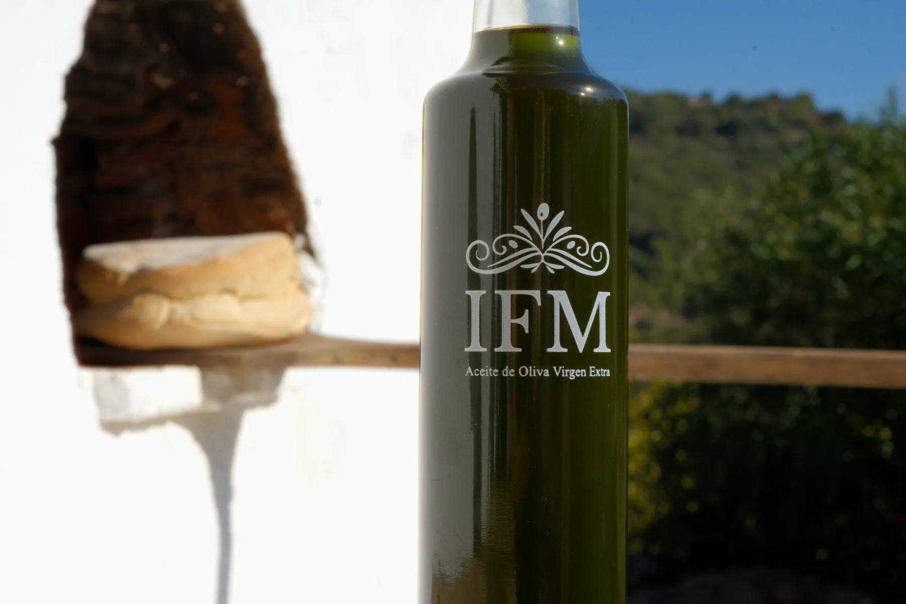 La botella de IFM y un pan en el hueco de una pared encalada.