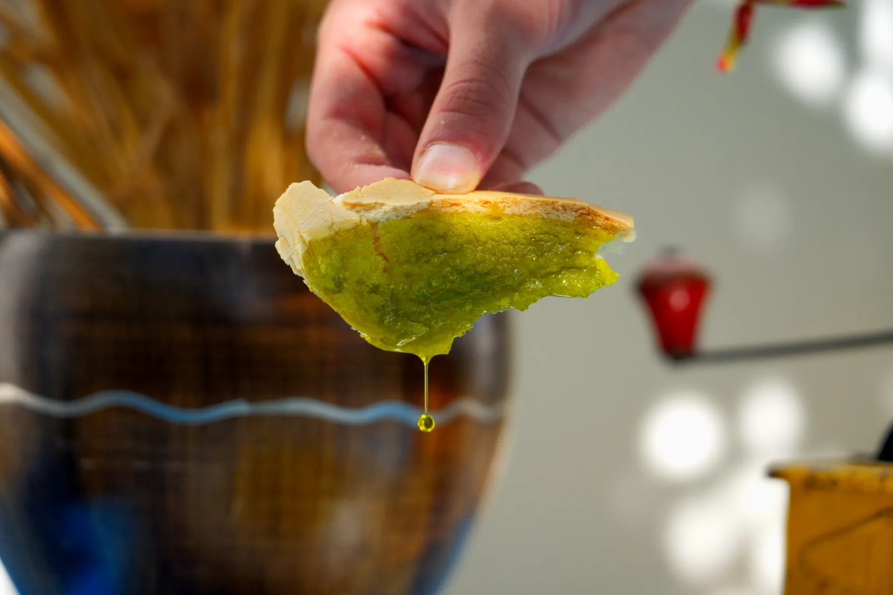 Un trozo de pan mojado en aceite gotea sobre el plato.